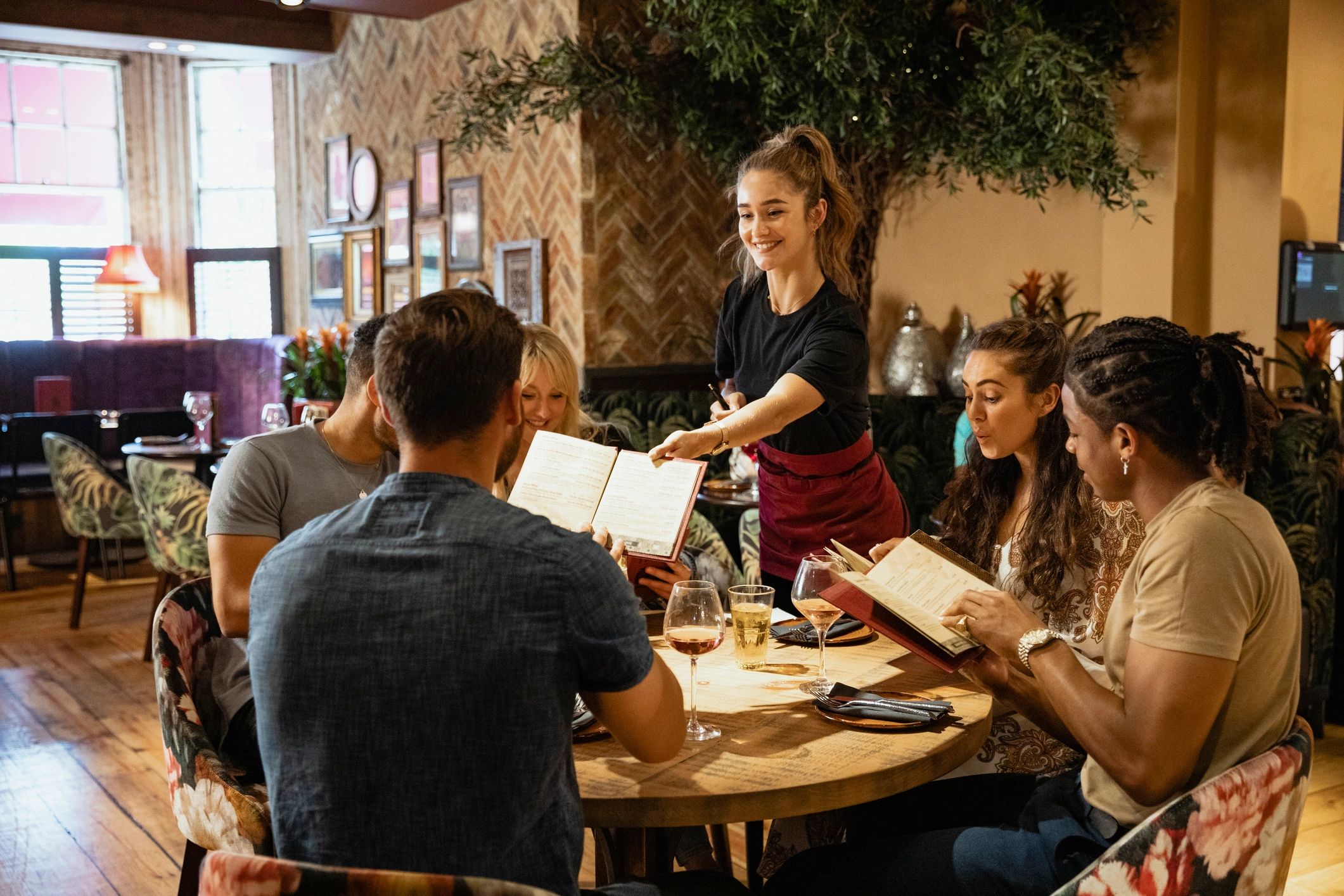 Asian restaurant dining scene with guests reviewing menus in a modern hospitality setting